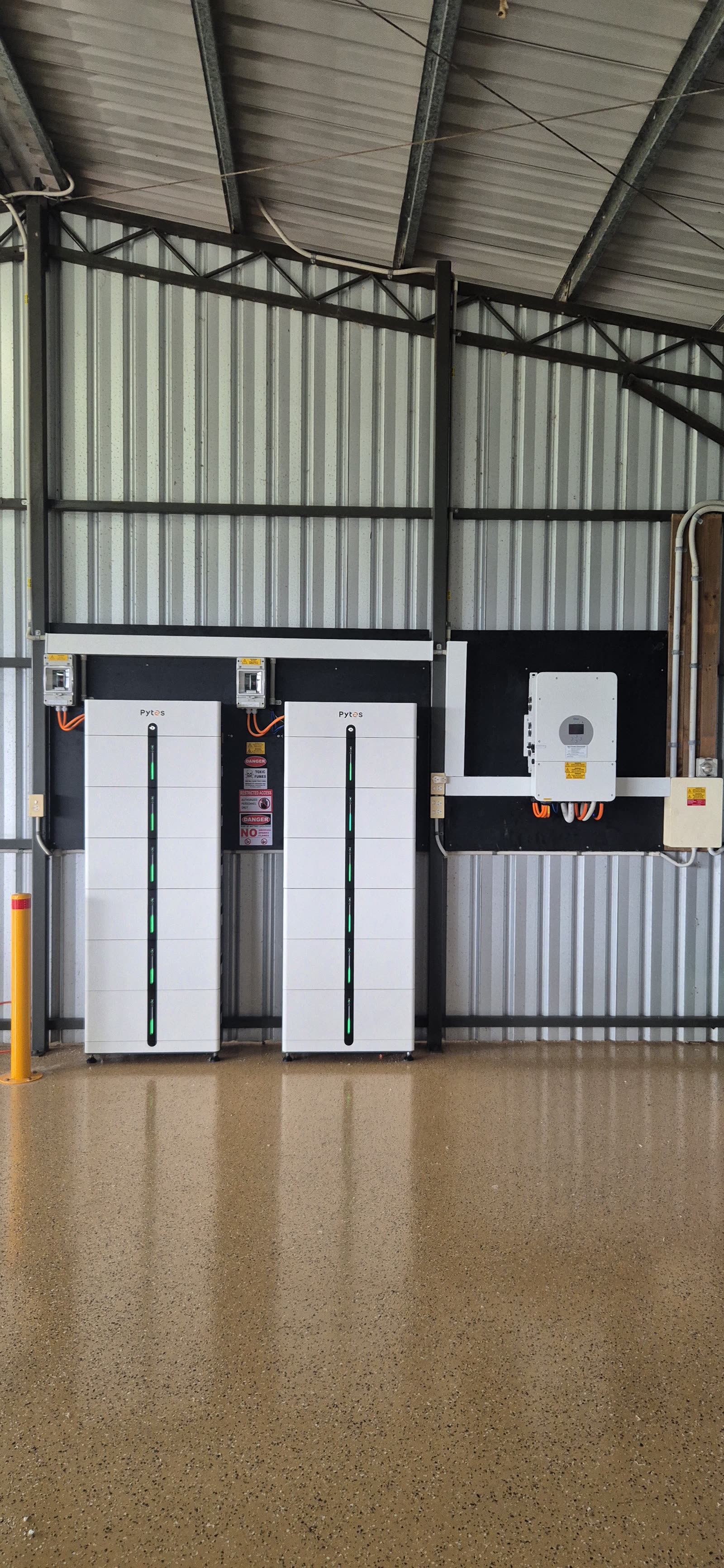 Twin Pytes Pi LV1 battery towers with switchboard and Deye inverter in a farm shed