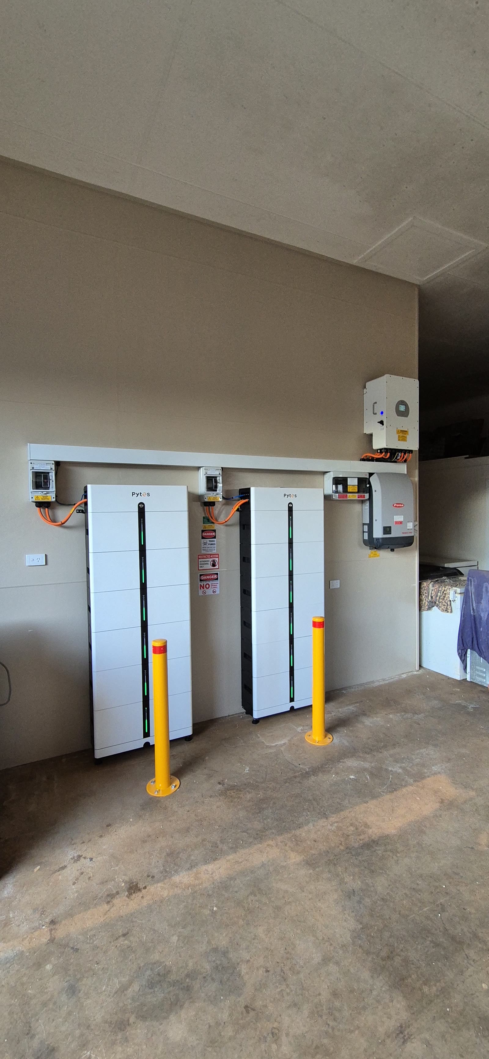 Two Pytes Pi LV1 battery stacks installed under a carport with a Deye inverter overhead